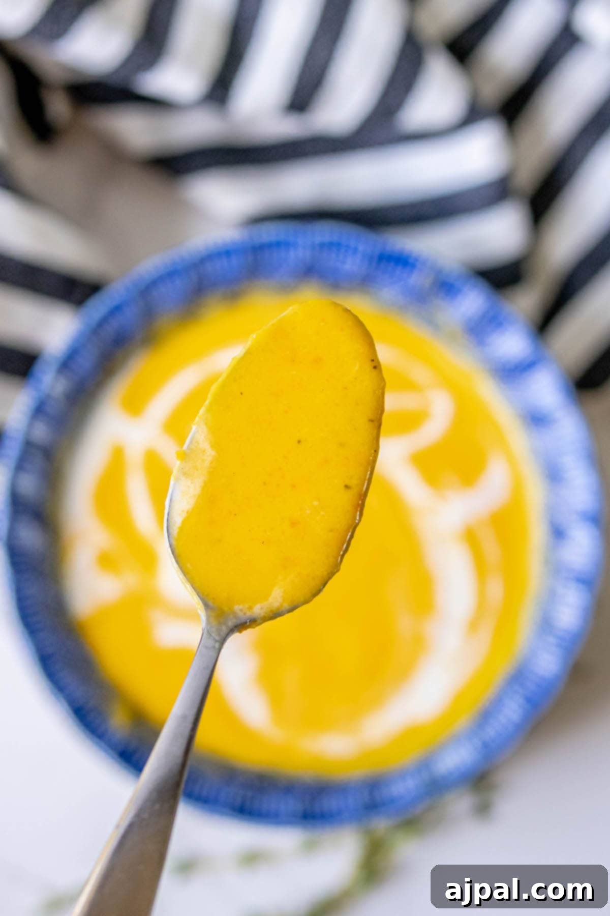 Golden Butternut Perfection 4 spoonful or orange soup with soup bowl in the background