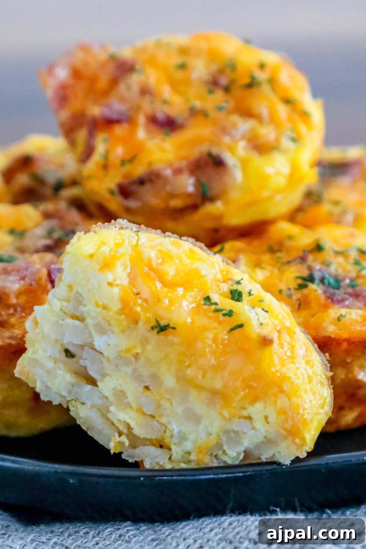 Hashbrown Egg Nests 4 Several cups of cooked egg with bacon and chives stacked on top of each other