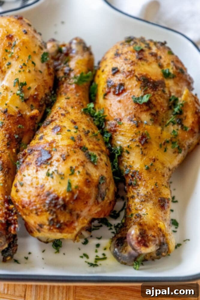 Tender Confit Chicken Legs 9 Roasted chicken legs on a plate with herbs, featuring a chicken leg confit recipe.
