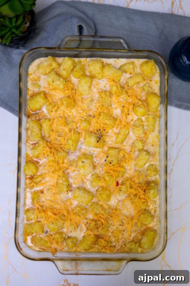 Hearty Tater Tot Breakfast Bake 12 Egg and milk mixture being poured over the tater tots and vegetables in the casserole dish.