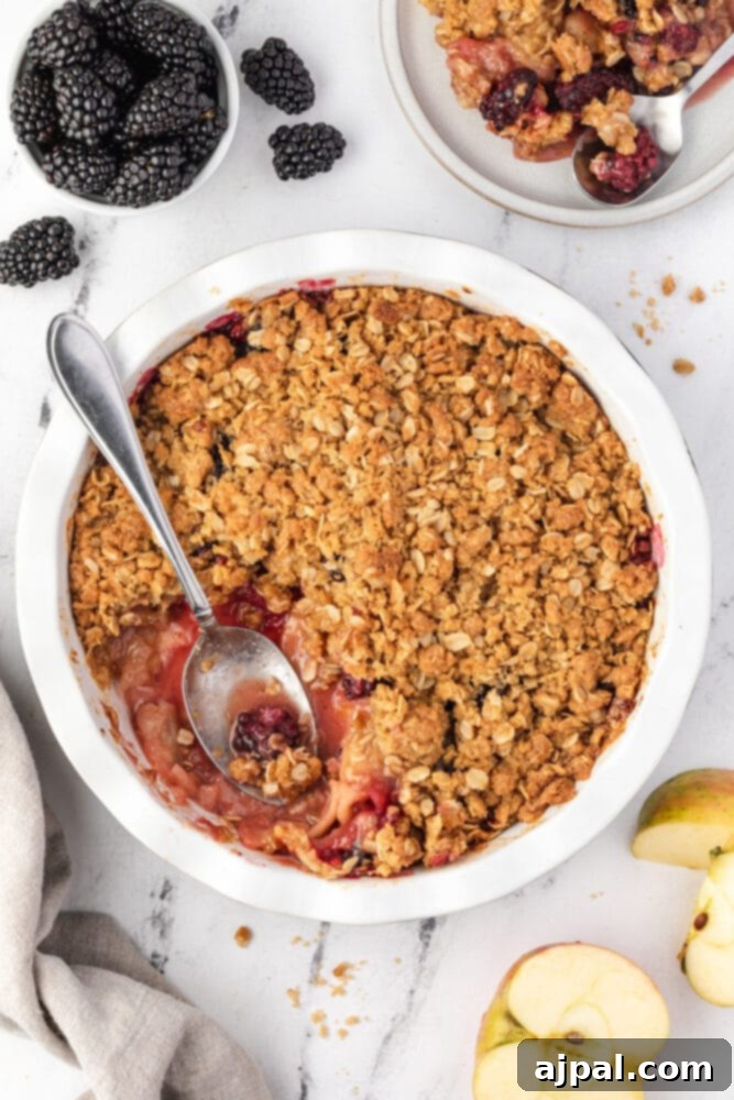 Apple and Blackberry Crumble 4 Blackberry crumble served in a white bowl with a spoon