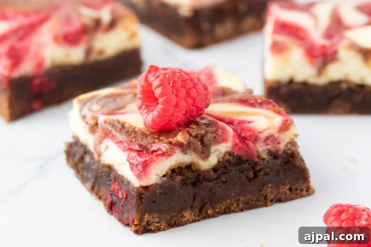 Ultimate Raspberry Cheesecake Brownies 3 Marbled raspberry cheesecake brownies with fresh raspberries.