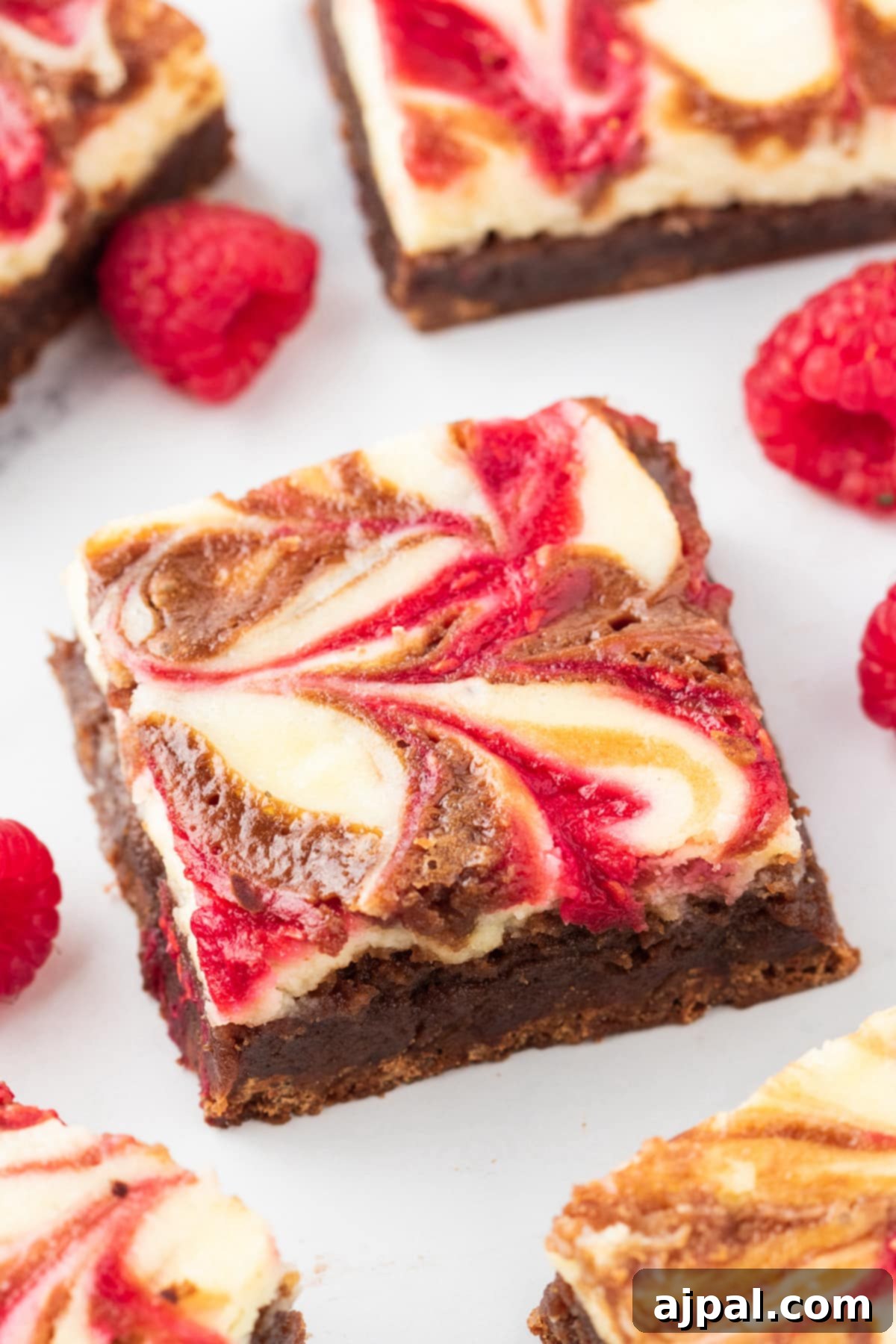 Ultimate Raspberry Cheesecake Brownies 4 Easy Raspberry Cheesecake Brownies with a chocolate swirl.