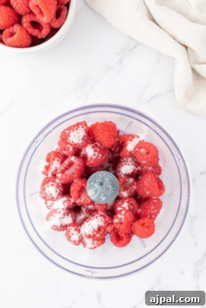Ultimate Raspberry Cheesecake Brownies 6 raspberries and sugar in a bowl