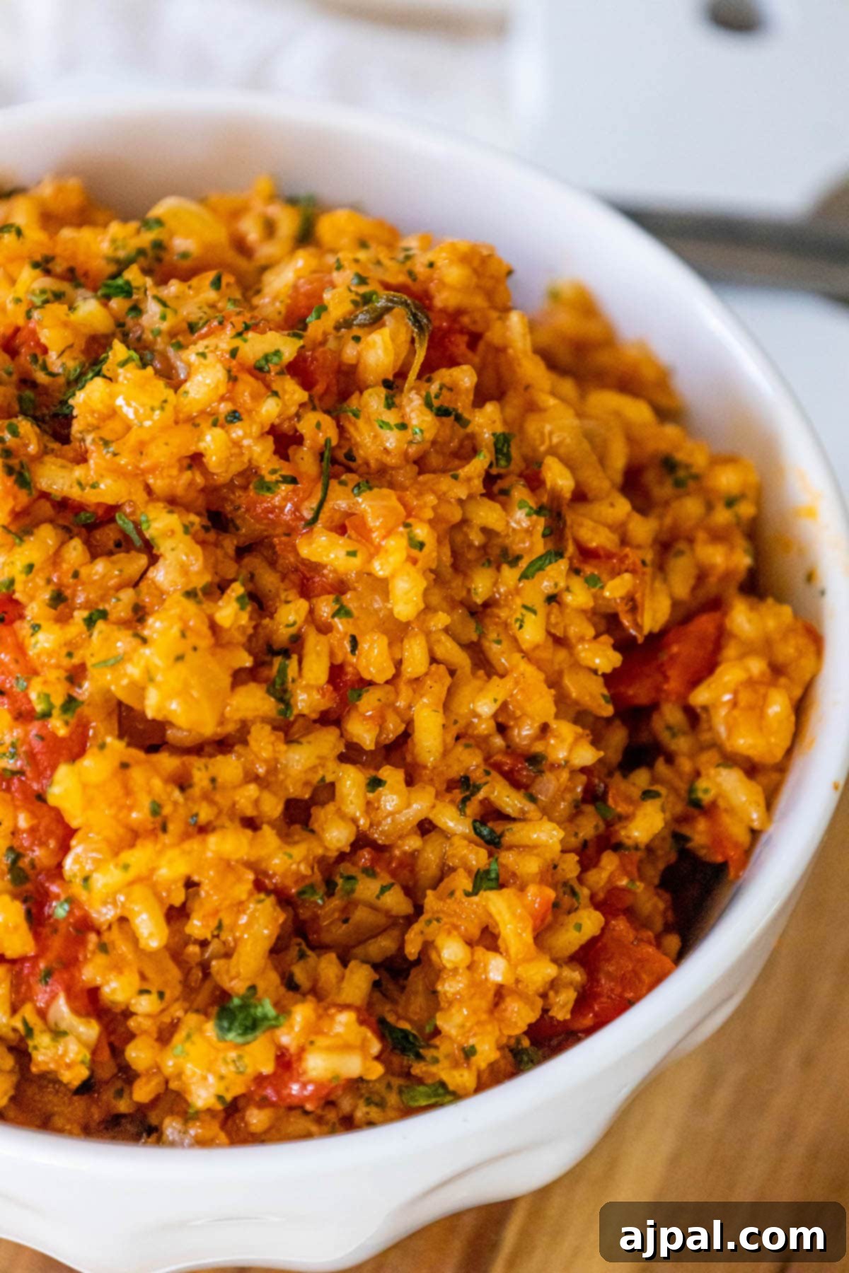 A beautifully presented bowl of easy Mexican rice, adorned with fresh tomatoes and herbs, inviting you to taste its authentic flavors.