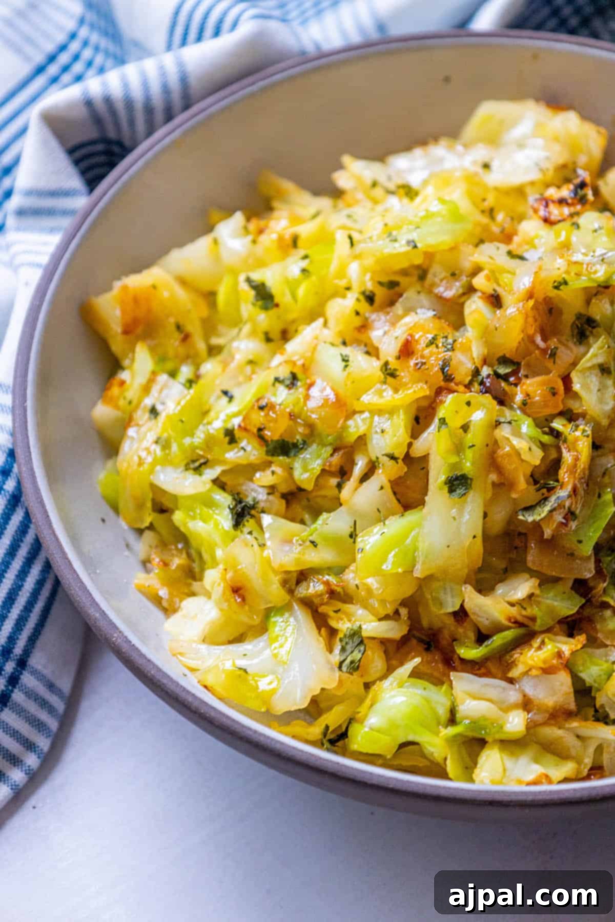 Caramelized Cabbage and Onions 2 A vibrant bowl of caramelized cabbage and onions, showcasing its golden-brown perfection, on a rustic wooden table.