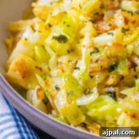 A serving bowl of sauteed cabbage with onions on a blue and white checkered cloth, inviting and delicious.