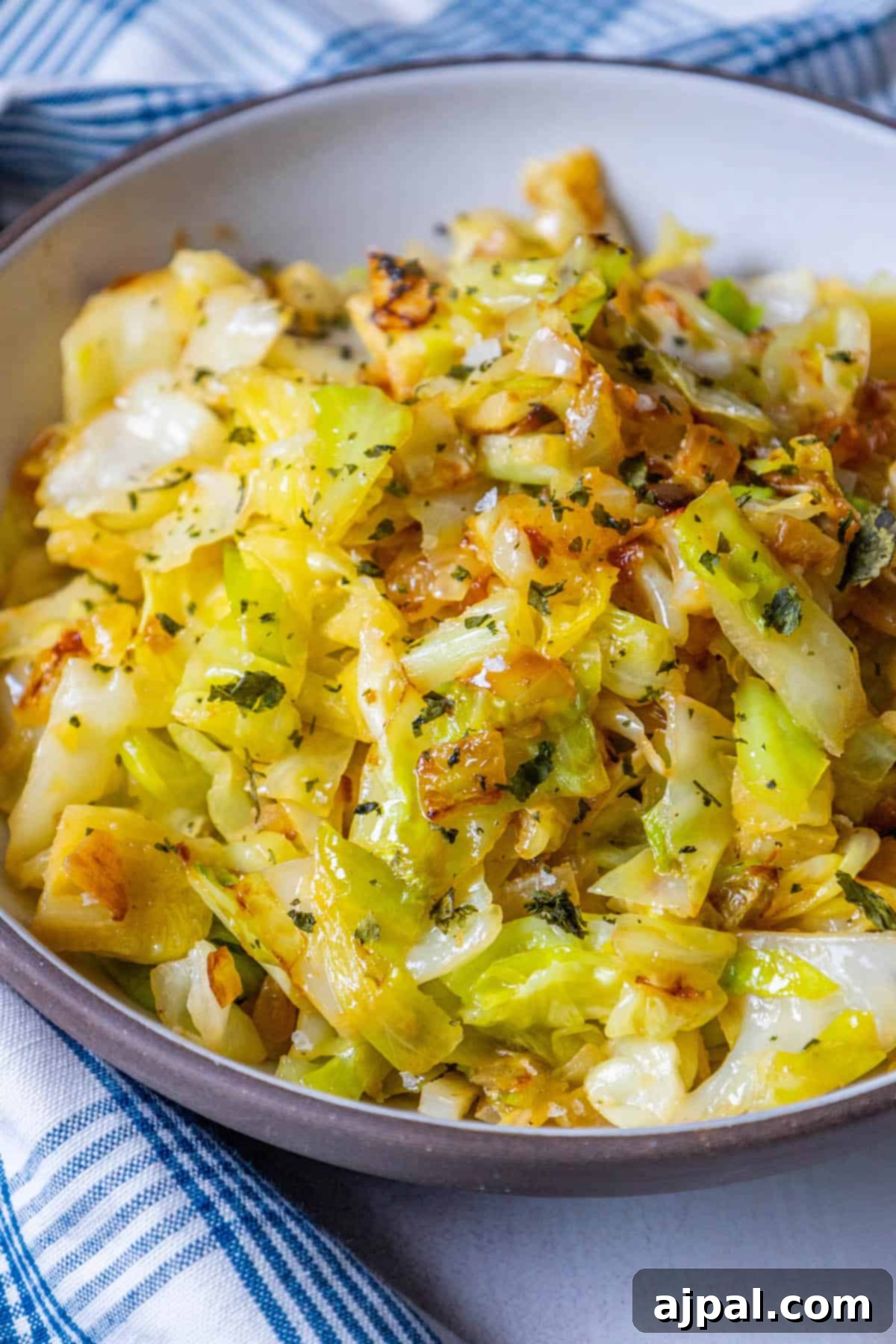Caramelized Cabbage and Onions 4 A generous serving of sautéed cabbage and onions, garnished with fresh herbs, presented beautifully on a blue and white cloth.