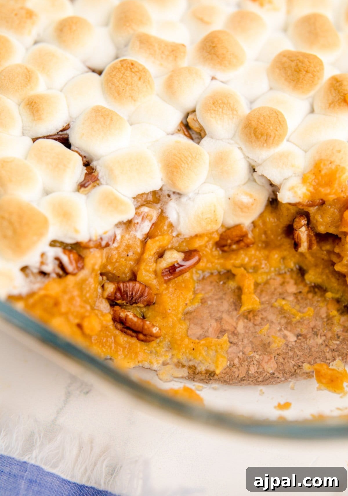 Golden Sweet Potato Delight 3 sweet potato with pecans and marshmallows with a scoop out of it