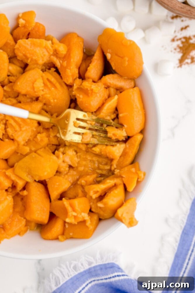 Golden Sweet Potato Delight 5 fork mashing sweet potatoes
