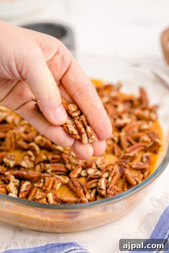 Golden Sweet Potato Delight 10 pecans being put on mashed sweet potato