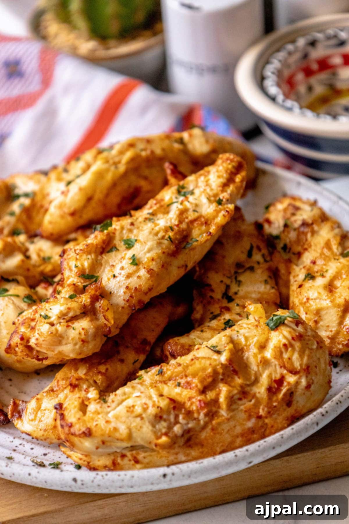 A plate of perfectly grilled Georgian chicken breasts on a wooden board, ready for carving and serving.