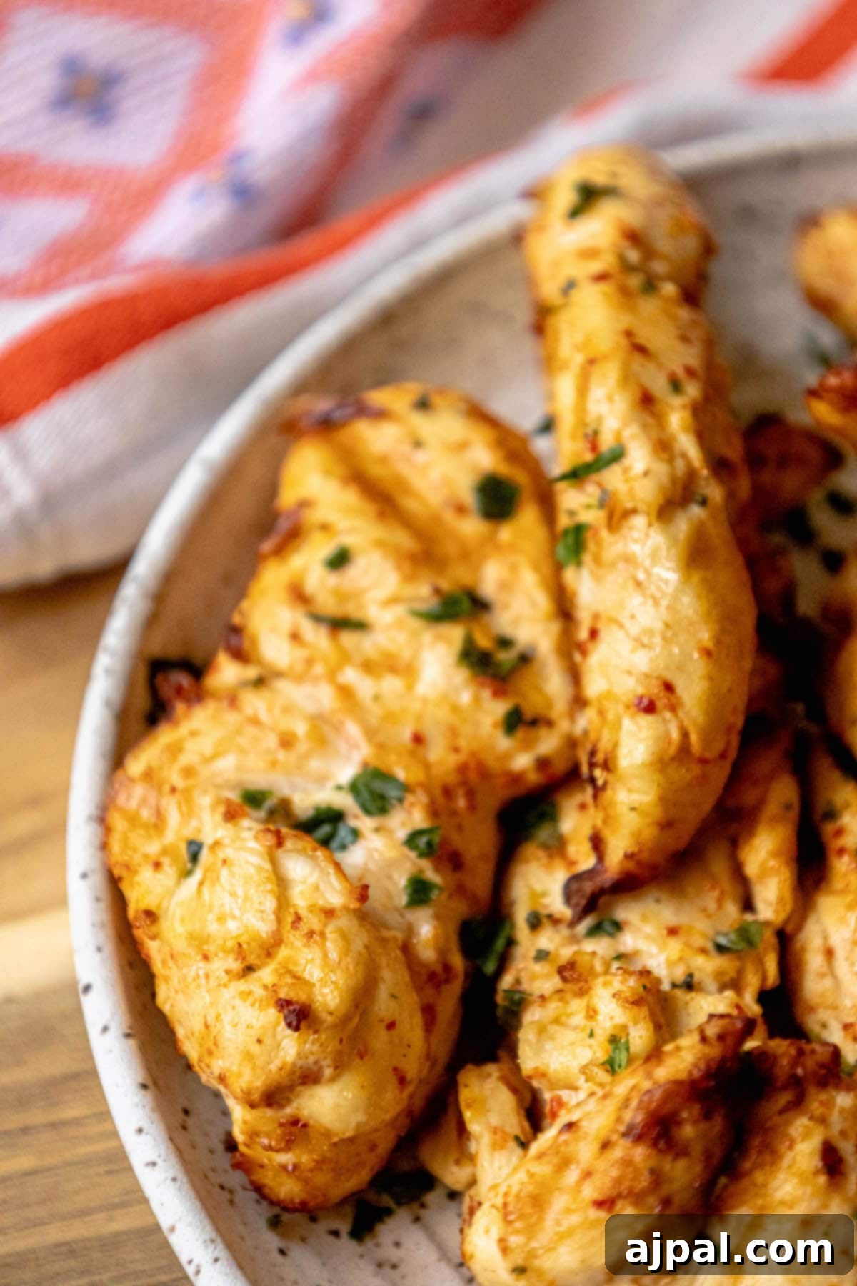 Grilled Ajika Chicken skewers elegantly arranged on a white plate, garnished with fresh herbs, ready to be served.