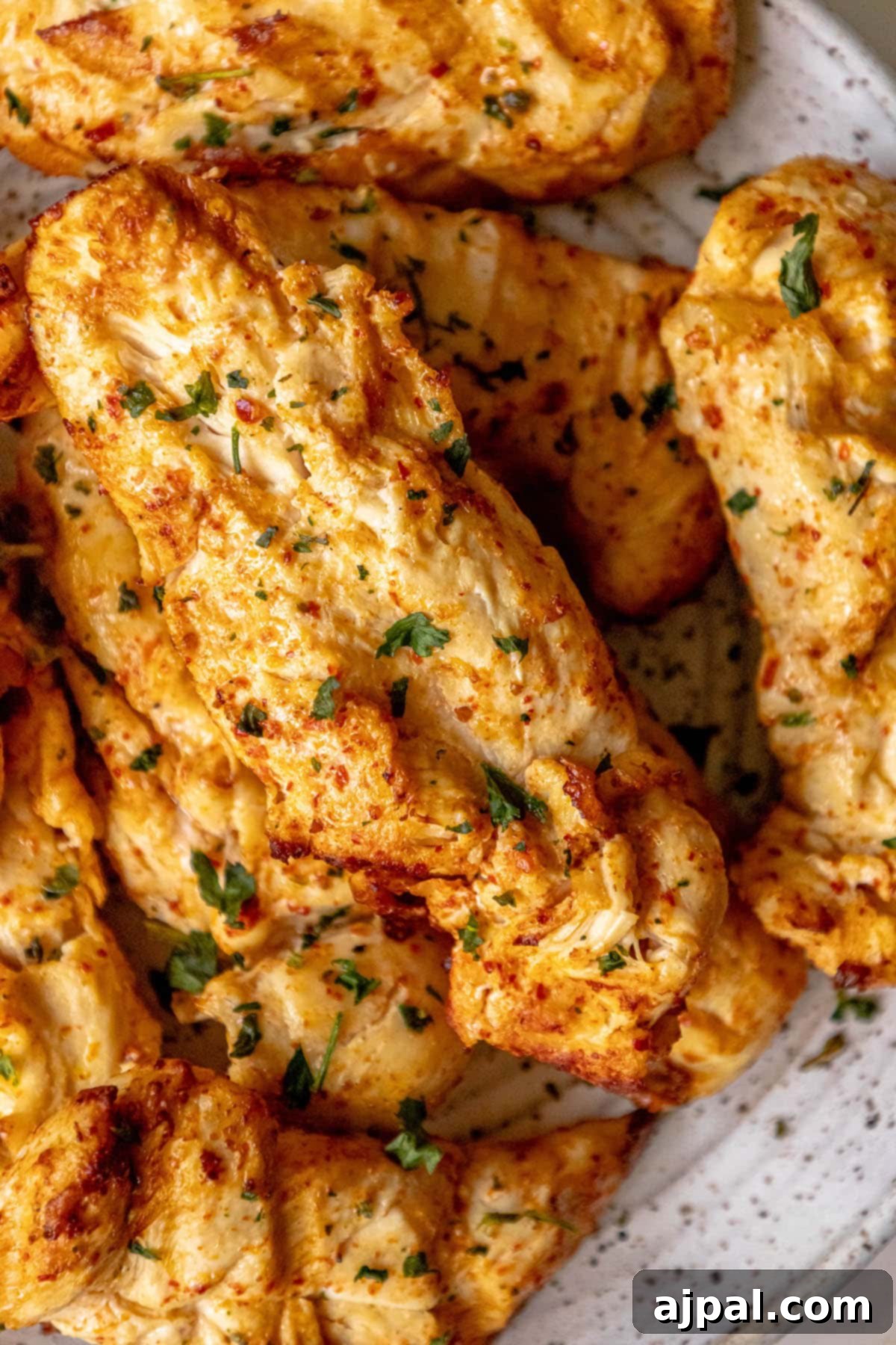 Grilled Ajika Chicken wings served beautifully on a plate with fresh parsley, highlighting the dish's vibrant flavors.
