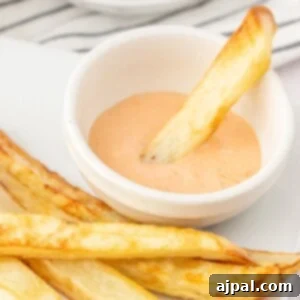 Ultimate Fry Dip 9 French fry being dipped into a small cup of fry sauce