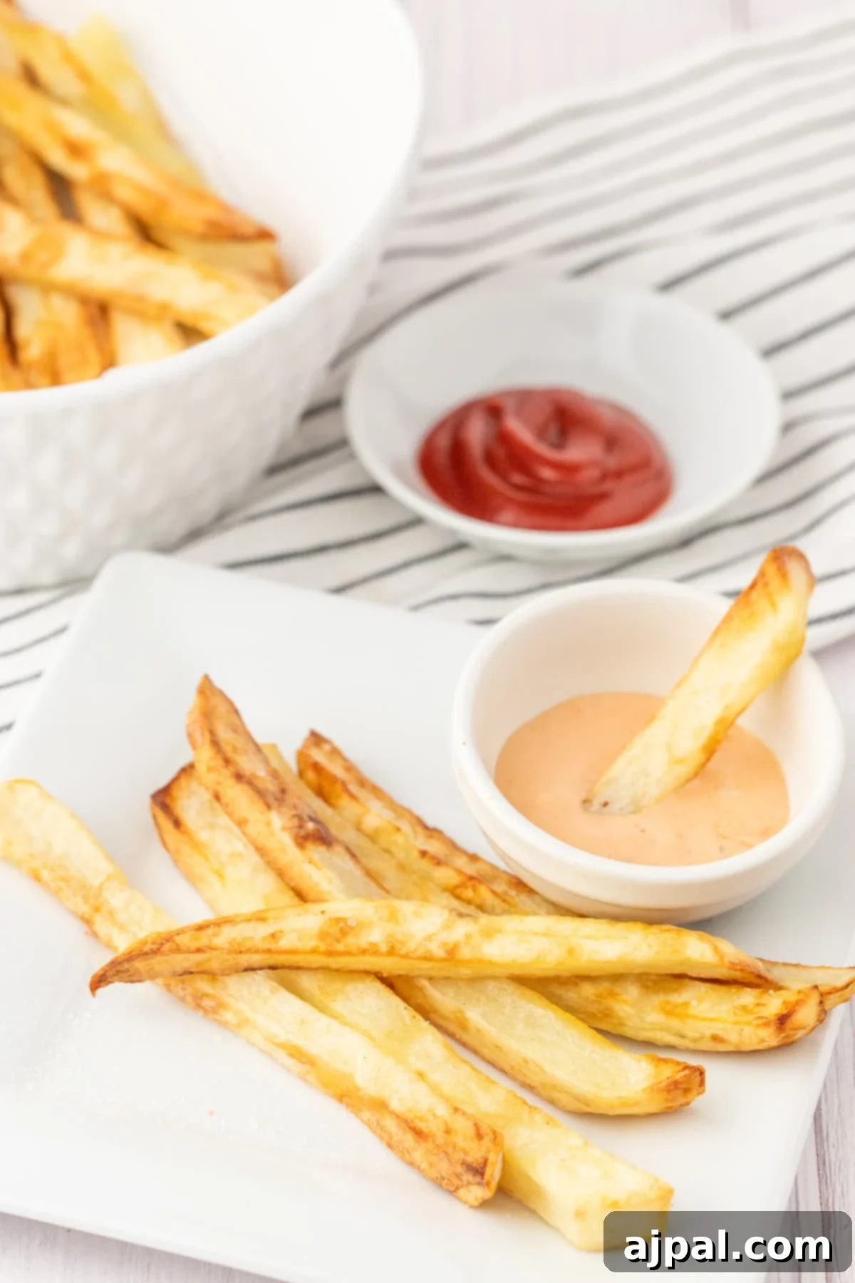 Ultimate Fry Dip 6 A French fry being dipped into a small cup of creamy, homemade French fry sauce, highlighting its perfect texture.