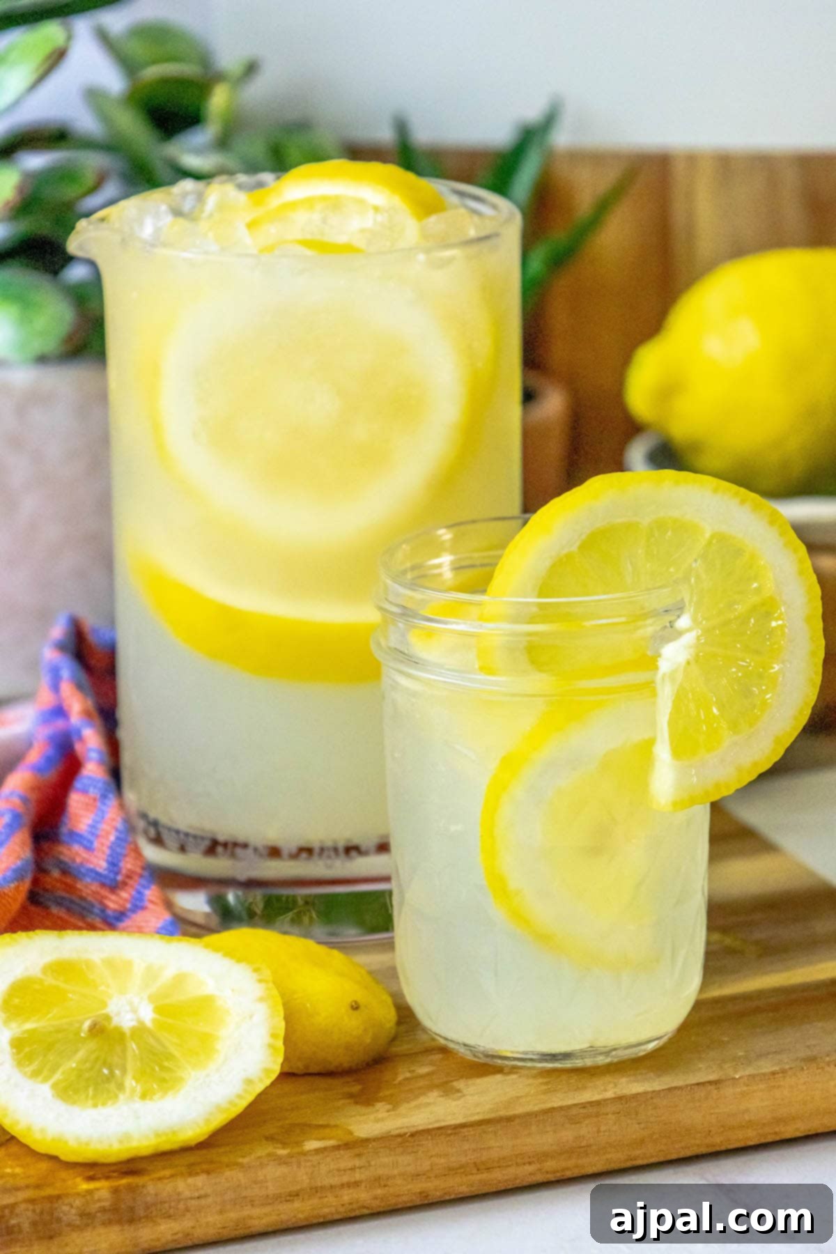 A beautifully composed image of a refreshing pitcher of homemade lemonade, garnished with fresh lemon slices, resting on a wooden cutting board, ready to be enjoyed.