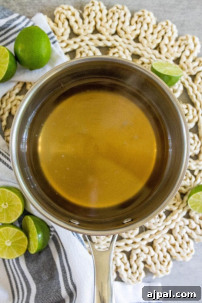 The process of making simple syrup for limeade in a saucepan.