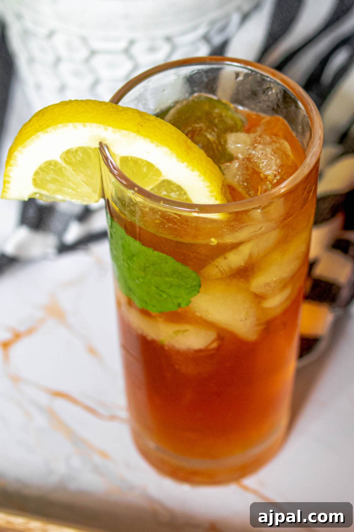 Arnold Palmer's Signature Sips 3 A perfectly chilled Arnold Palmer drink, a harmonious blend of iced tea and lemonade, adorned with fresh lemon slices and mint sprigs in an elegant pitcher. A quintessential thirst-quencher.