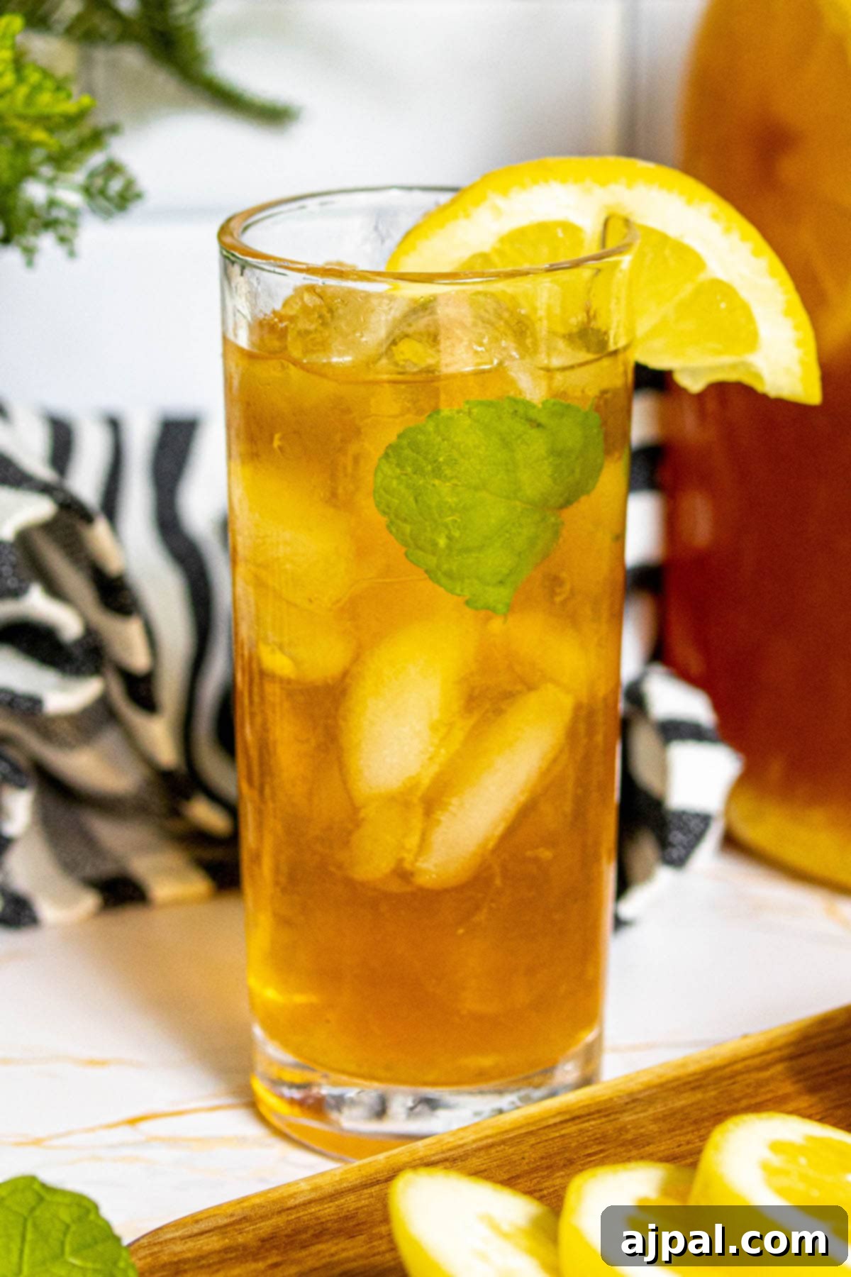 Arnold Palmer's Signature Sips 5 A refreshing homemade Arnold Palmer drink, artfully presented in a tall glass with ice, garnished with bright lemon slices and fresh mint leaves.