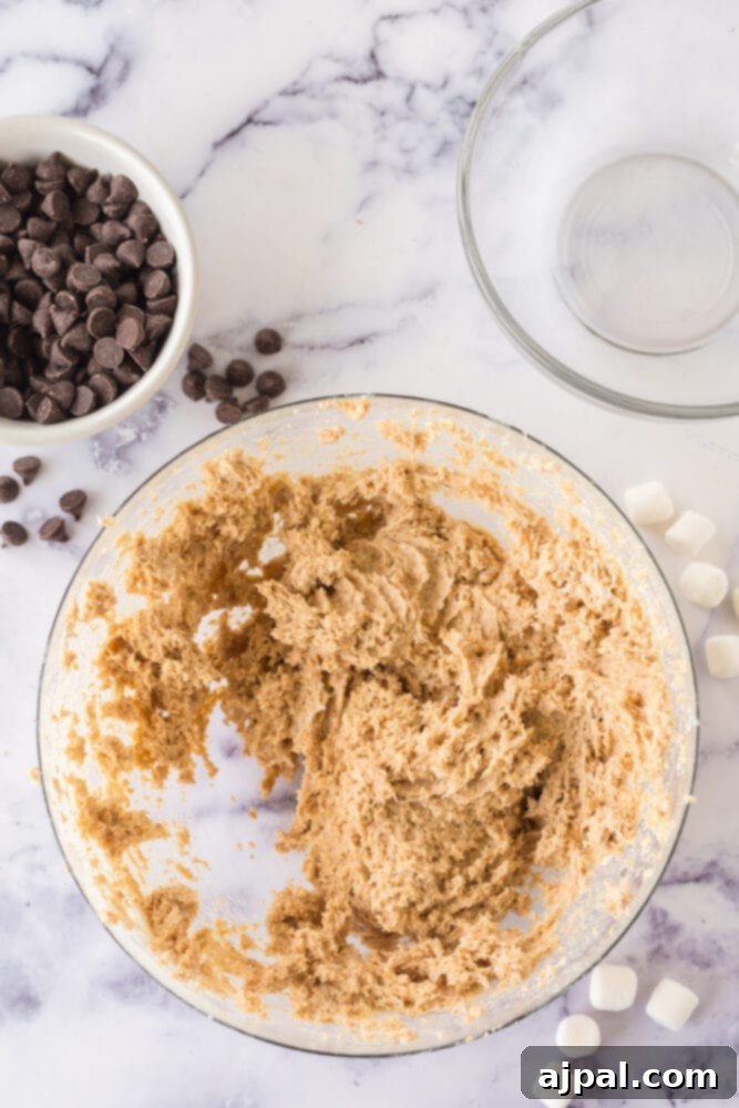 A bowl featuring marshmallow fluff, sugar, and graham cracker crumbs, perfectly combined for S'mores truffle base.