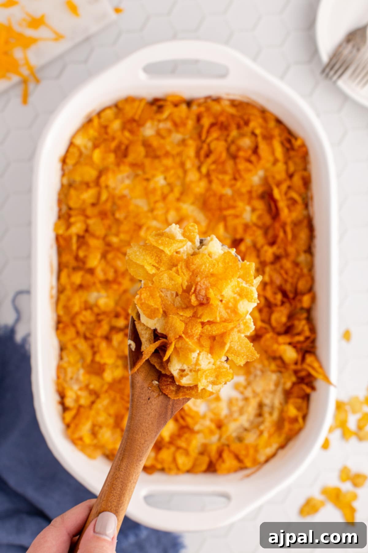 A person enjoying a spoonful of crunchy cheesy tater tot casserole, highlighting the delicious texture.