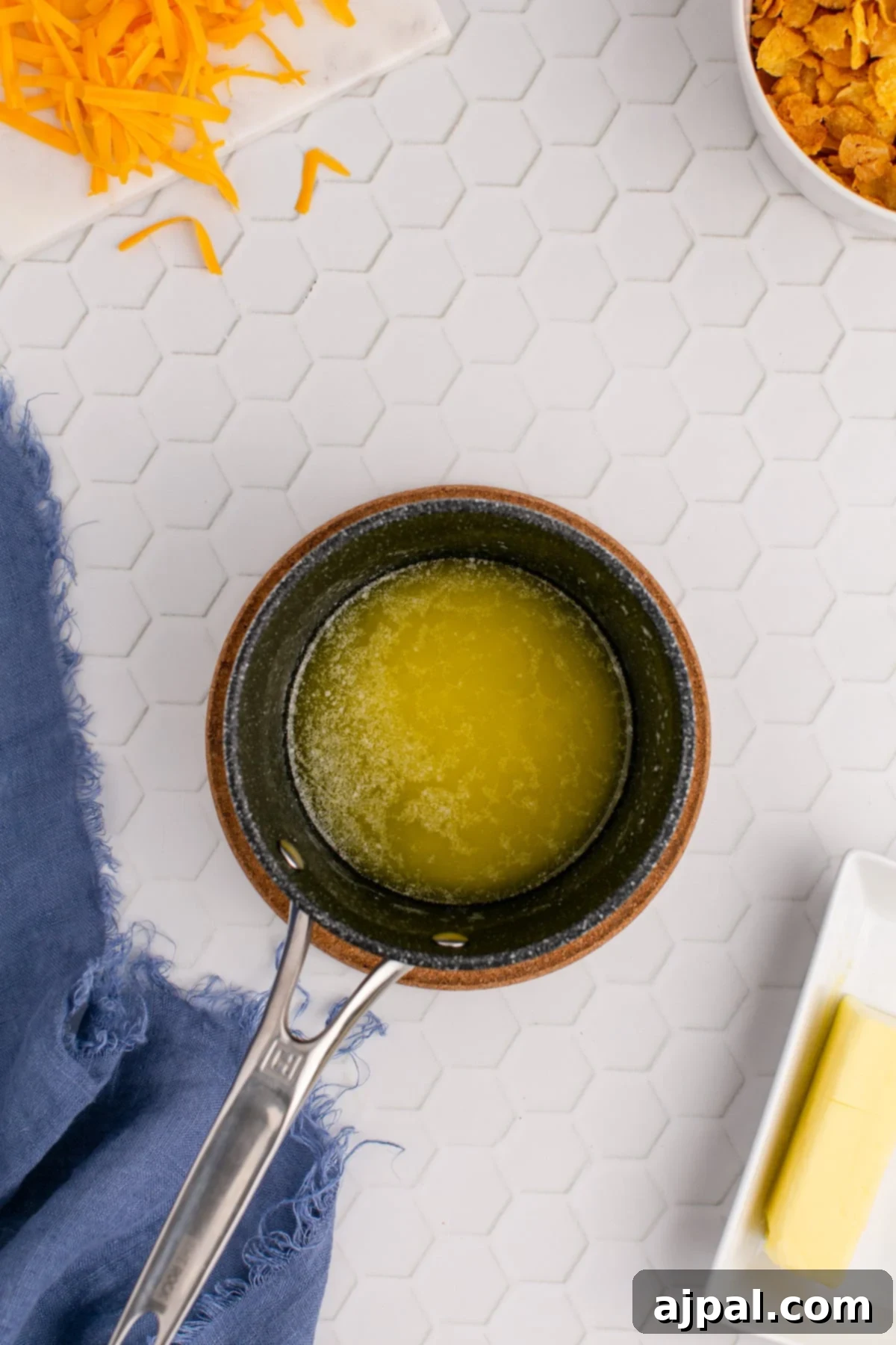 Melted butter in a small saucepan on a stovetop, shimmering and ready for use in the recipe.