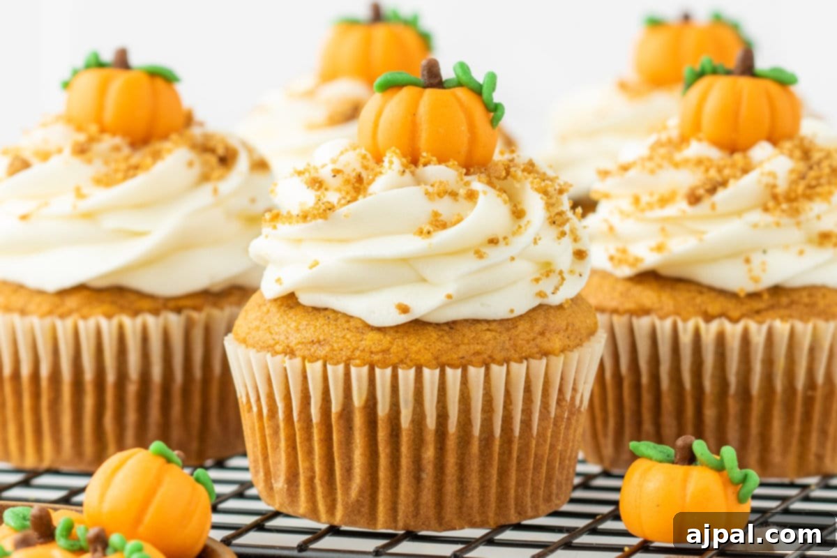 Golden Pumpkin Spice Cupcakes 11 Pumpkin cupcakes on a cooling rack, frosted and garnished, showcasing the best easy pumpkin cupcakes.