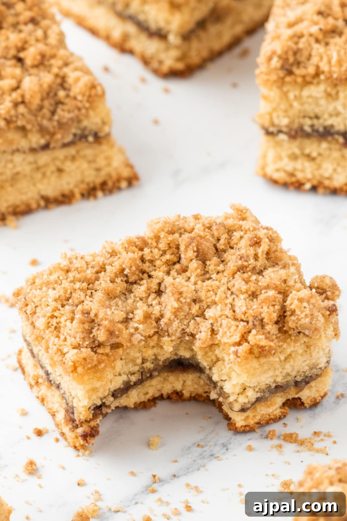 A delicious slice of coffee cake with a bite taken out, showcasing its moist interior and crumbly topping, perfect as an effortless treat.