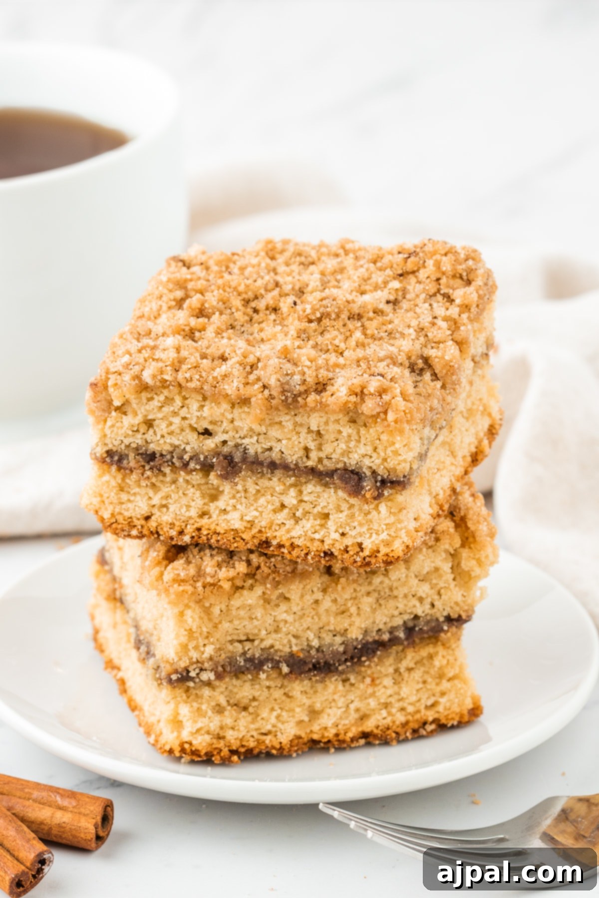 Coffee cake slices stacked elegantly on a table, ready for serving with a cup of coffee