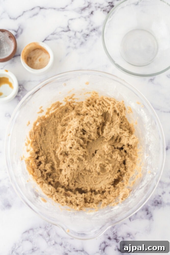 Snickerdoodle blondie batter mixed in a large bowl, showing a smooth, golden texture
