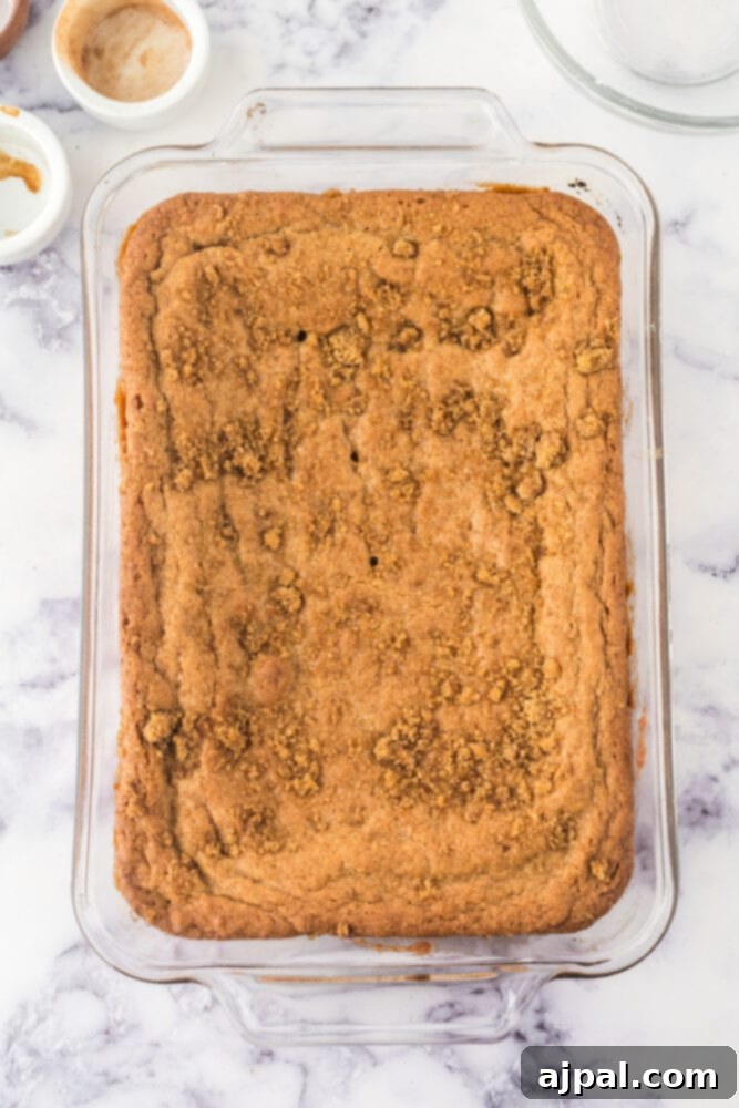 Baked Snickerdoodle Blondies cooling in a casserole dish on a table, golden brown and fragrant
