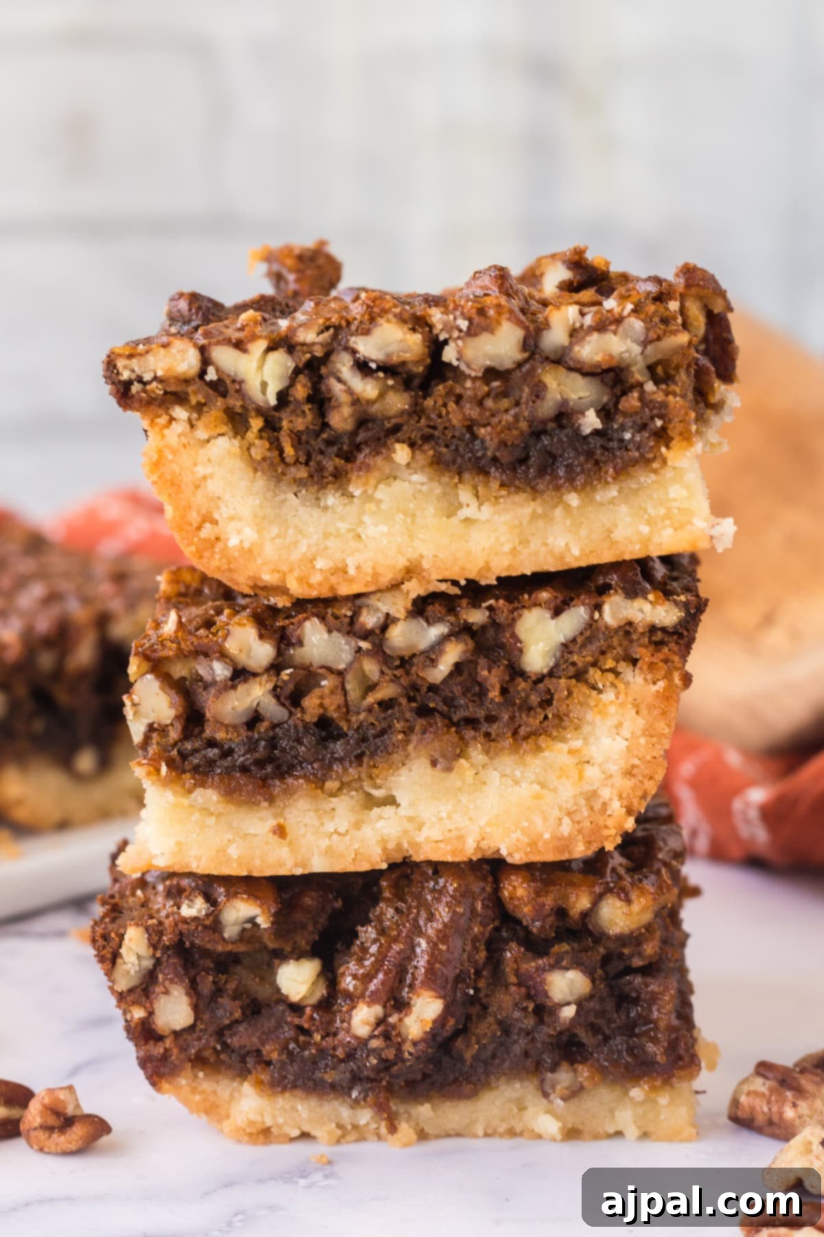 Pecan Pie Bars 2 Stacked pecan pie bars, showcasing their golden crust and glistening pecan topping.