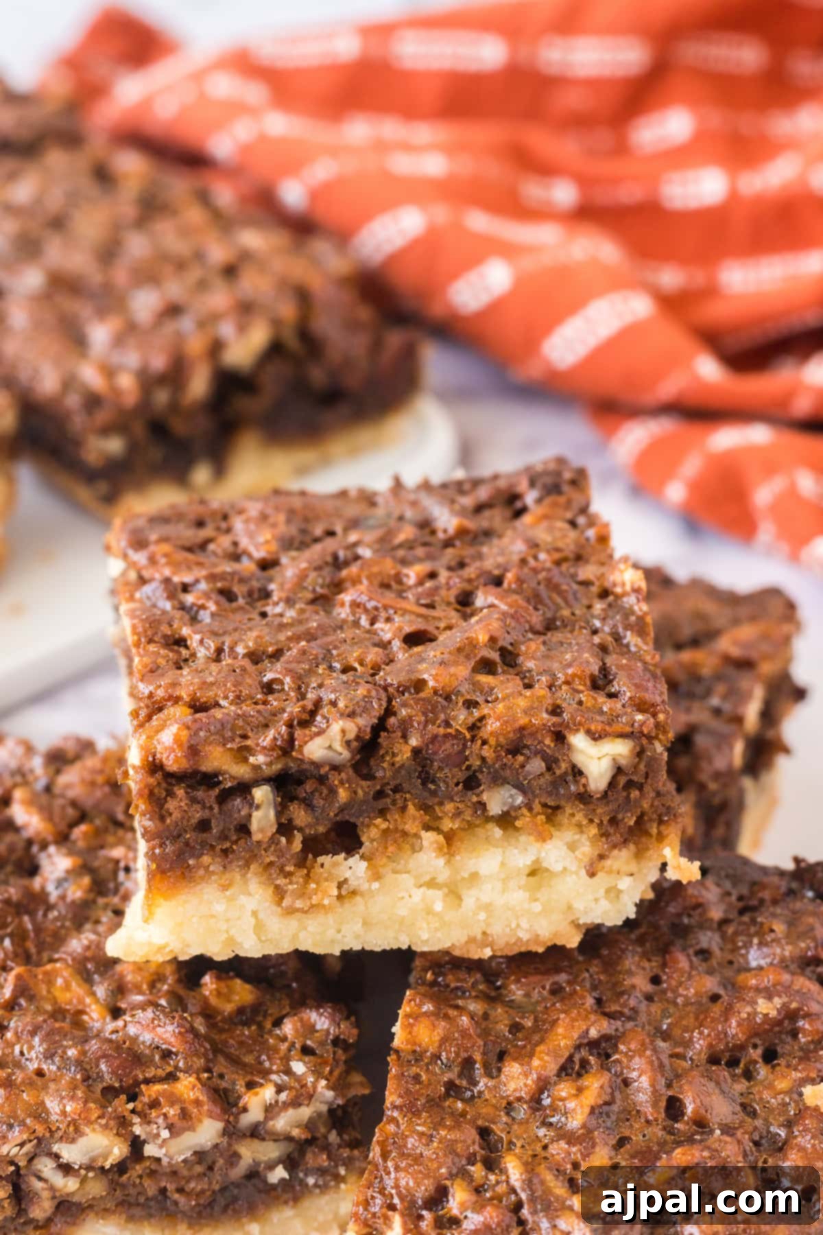Pecan Pie Bars 13 A stack of delicious Pecan Pie Bars on a white plate, ready to be enjoyed.