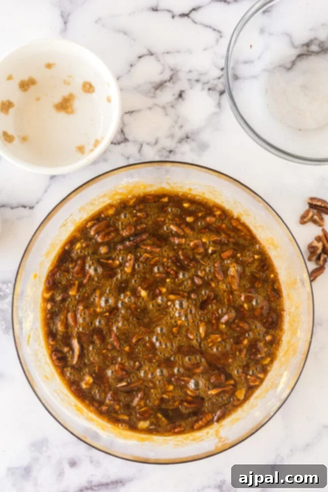 Pecan Pie Bars 9 Pecan pie topping mixture, rich and dark, in a clear glass bowl.