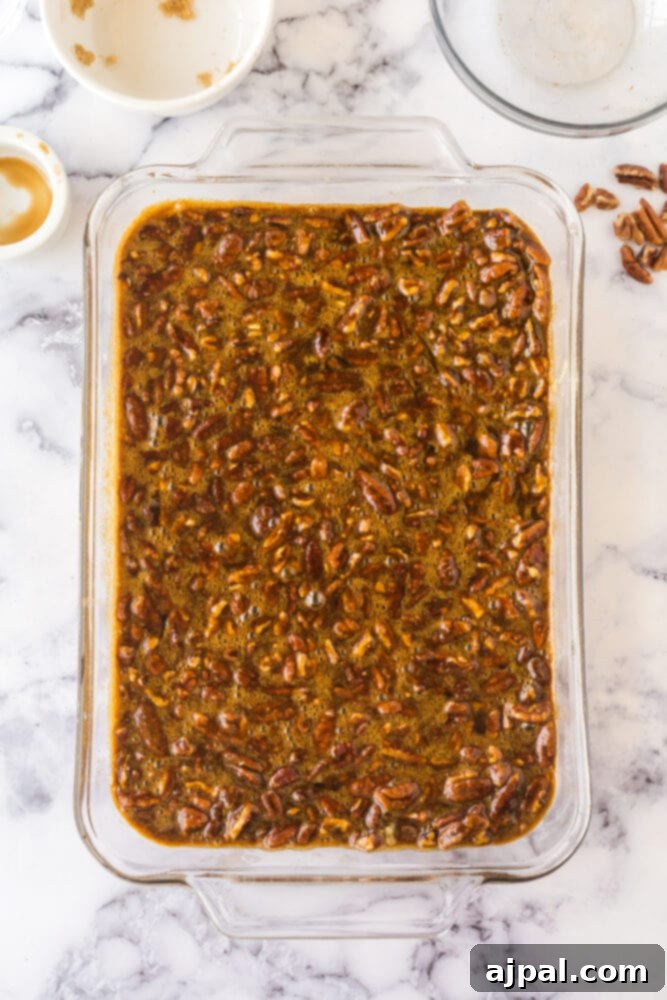 Pecan Pie Bars 10 Cookie dough base in a baking dish, generously topped with the pecan pie filling mixture.