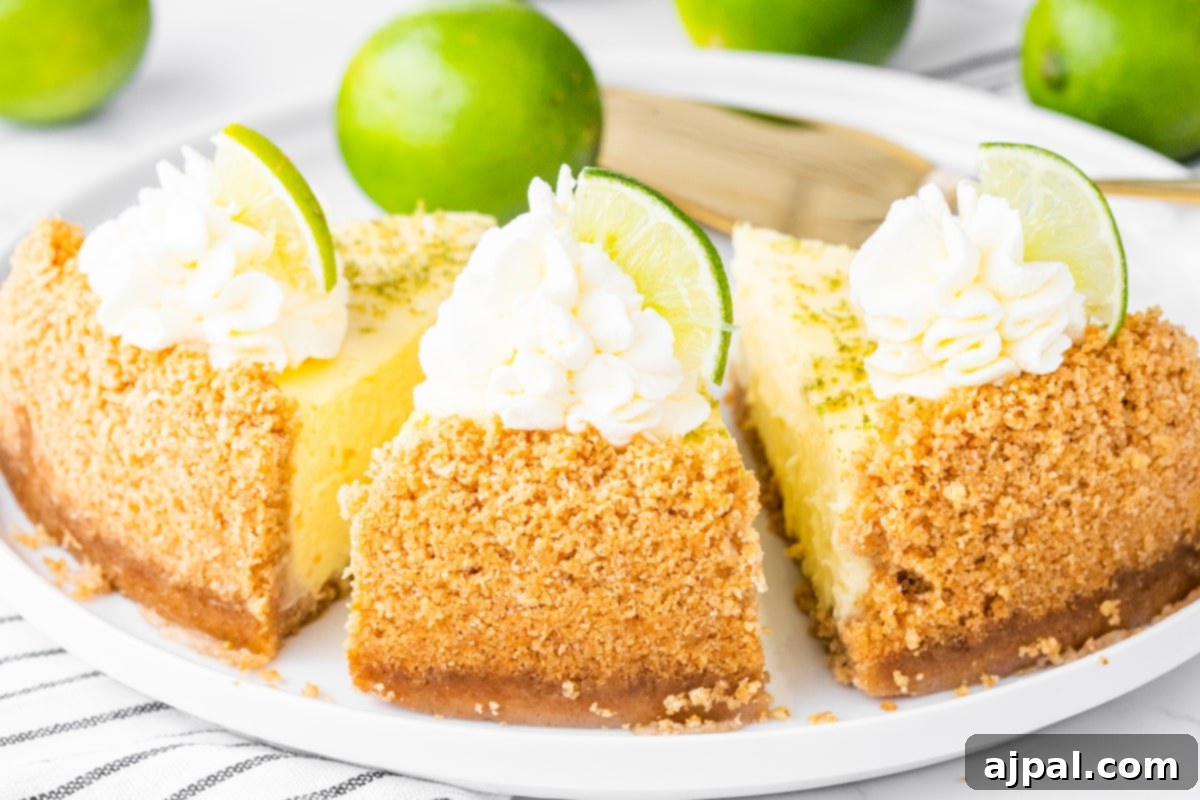 a slice of key lime cheesecake on a plate with a dollop of whipped cream and lime slices on top