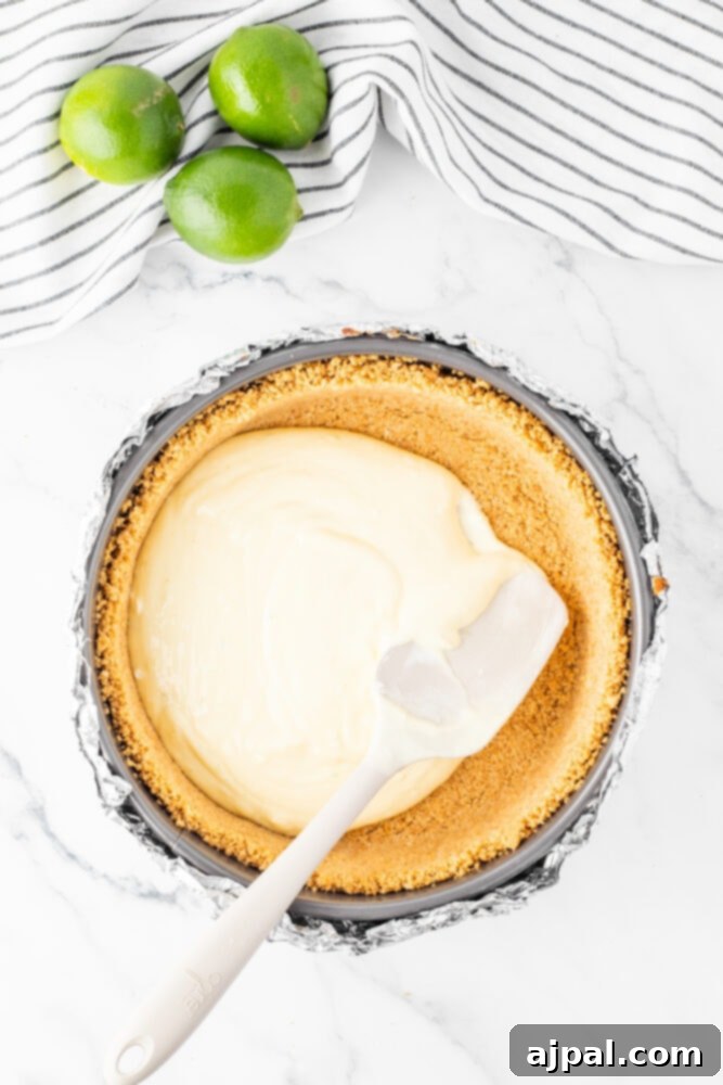 cheesecake batter being spread into cake pan