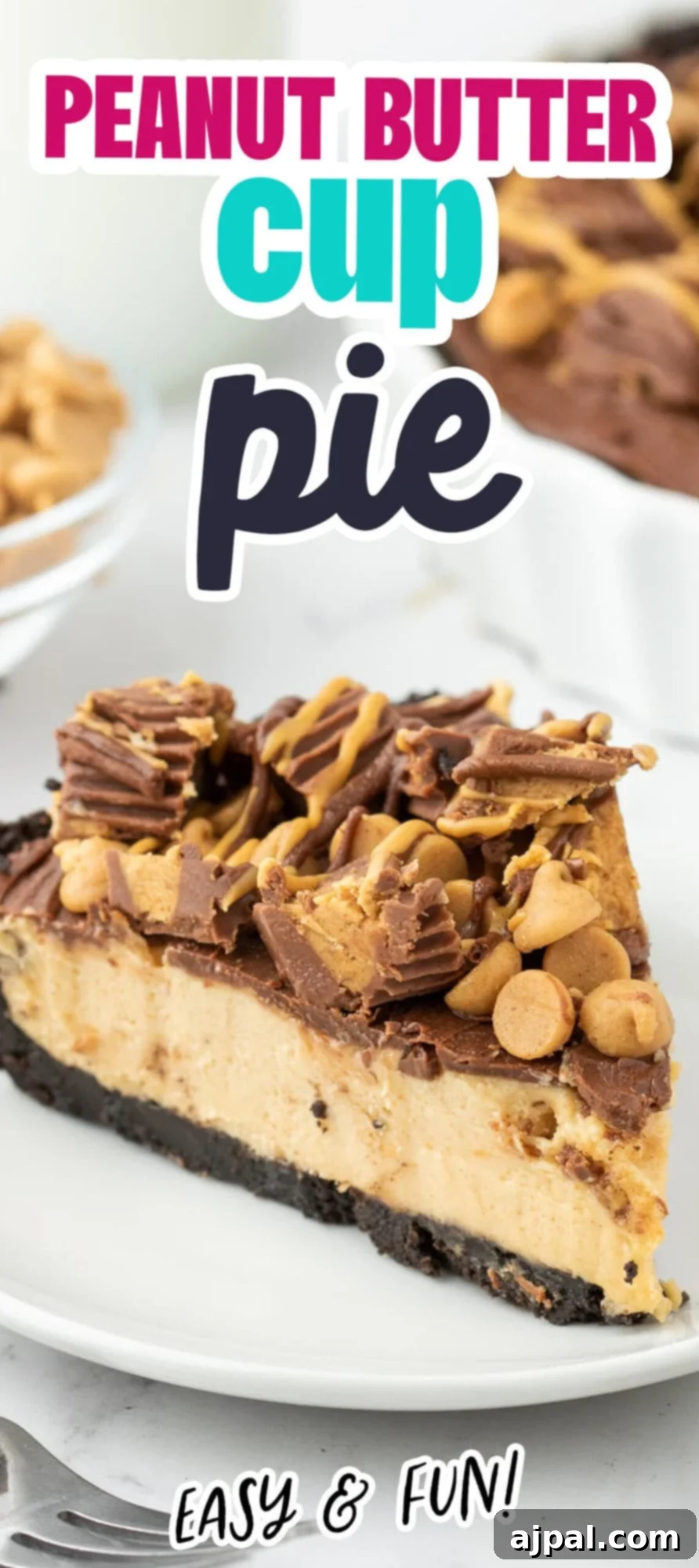 A whole Reese’s Peanut Butter Pie with a glossy chocolate top, adorned with mini peanut butter cups and chocolate chips, resting on a white surface.