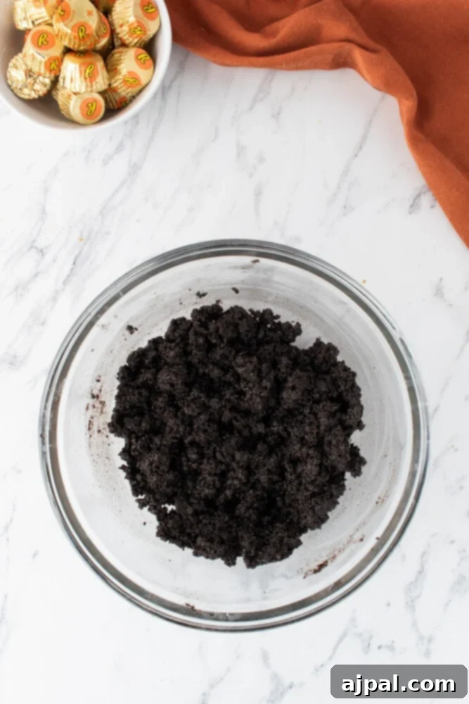 A bowl filled with finely crushed chocolate sandwich cookie crumbs, ready for making the pie crust.