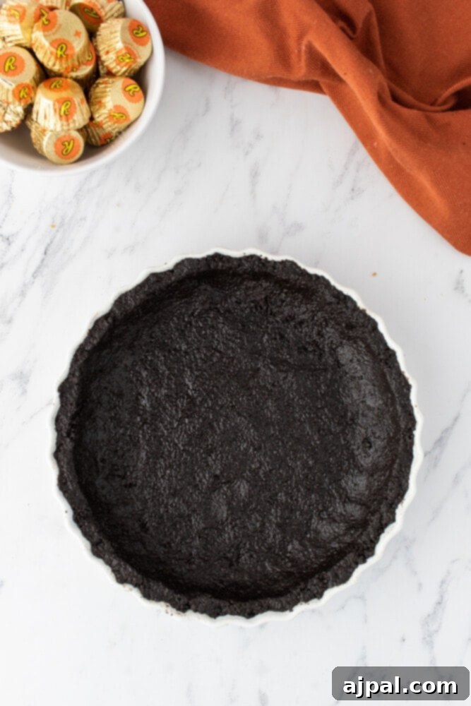A dark, pre-baked chocolate cookie pie crust set in a pie dish, waiting for its creamy filling.