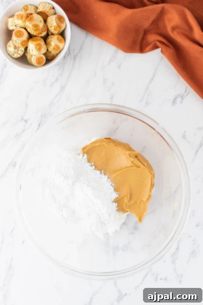 Creamy peanut butter and fluffy powdered sugar mixed together in a bowl, forming the base of the pie filling.
