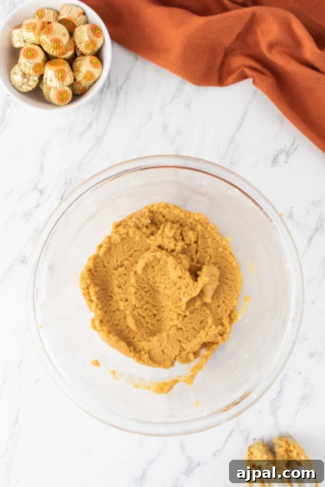 A close-up of smooth peanut butter in a bowl, showcasing its rich texture before being mixed into the pie filling.