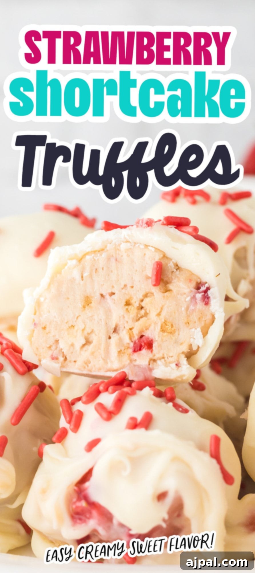 A stack of delicious strawberry shortcake truffles, coated in white chocolate and pink sprinkles, ready to be enjoyed.
