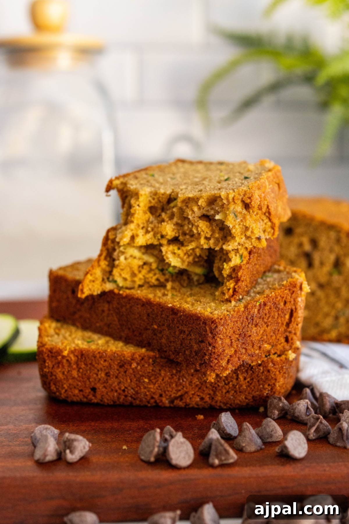 baked zucchini bread slices stacked on top of each other on a cutting board