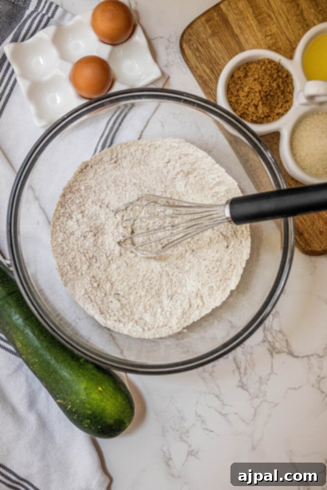 dry flour and cinnamon in a bowl with a whisk in it
