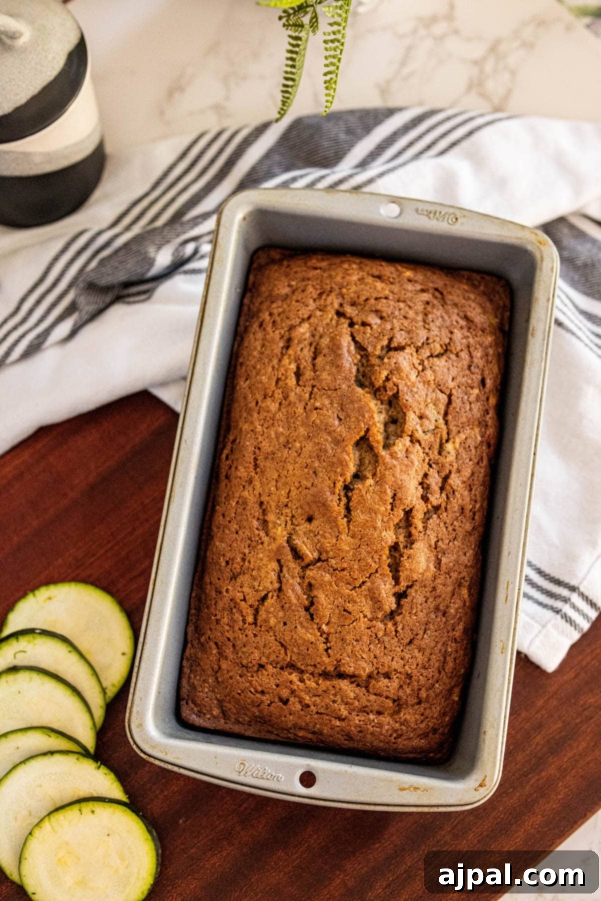 baked zucchini bread slices stacked on top of each other on a cutting board