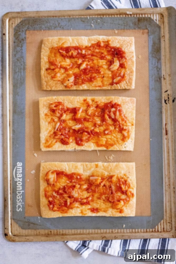 Ratatouille Tartlets 8 puff pastry with tomato sauce on a baking sheet
