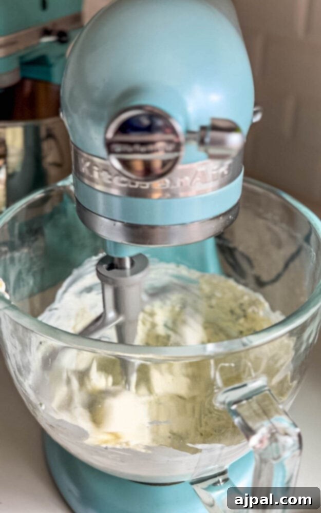 A creamy schmear mixture being blended in a stand mixer, demonstrating the mixing process.