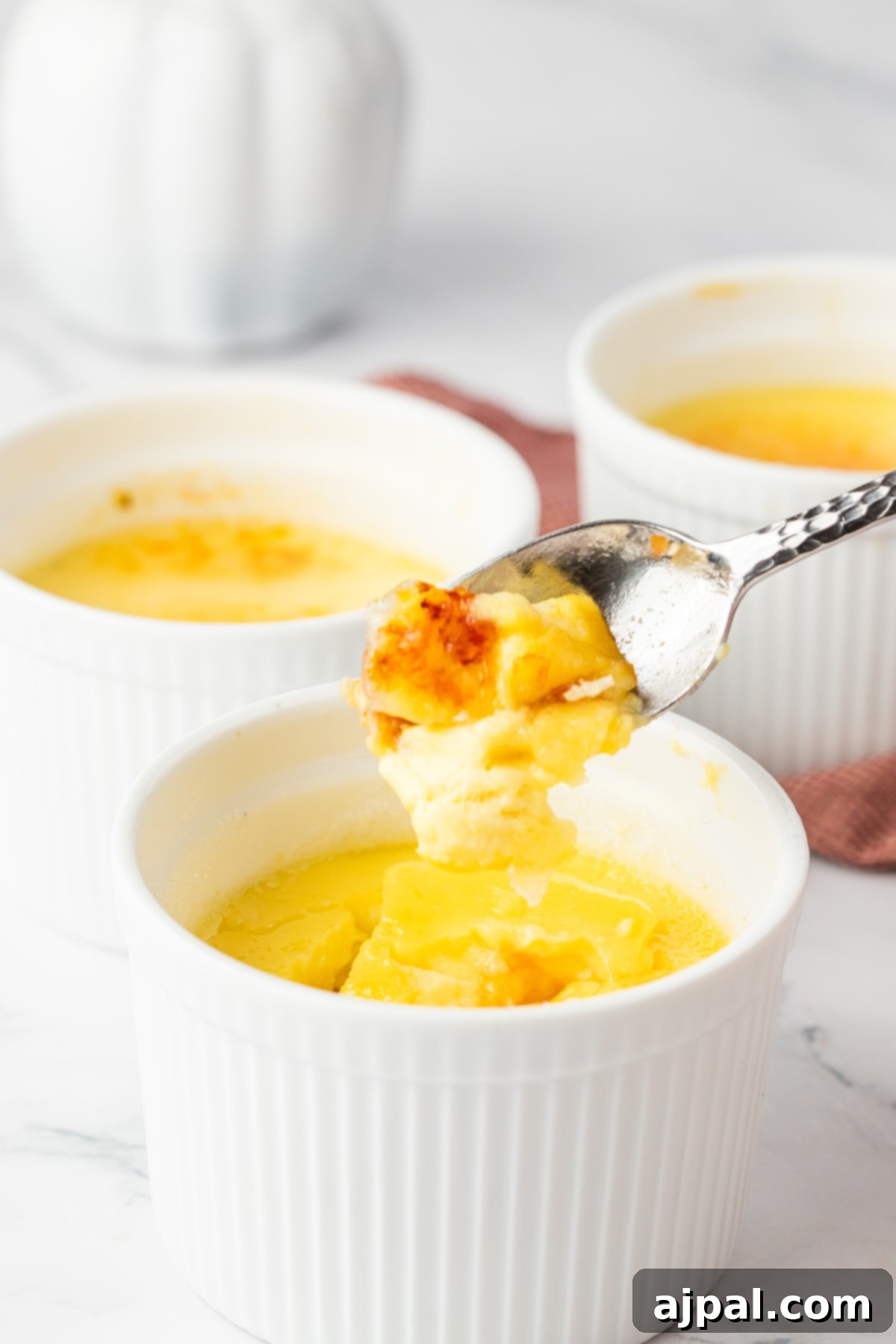 Your Instant Pot's Secret to Perfect Creme Brulee 2 Creme Brûlée in small white ramekins with a twine rope tied around the cups.